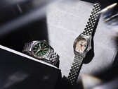 Seiko 5 Sports Field GMT HDB001 med grön urtavla och HDB002 med krämfärgad urtavla visas sida vid sida på femlänkade armband i rostfritt stål, båda med fast 24-timmarsring och orange GMT-visare.