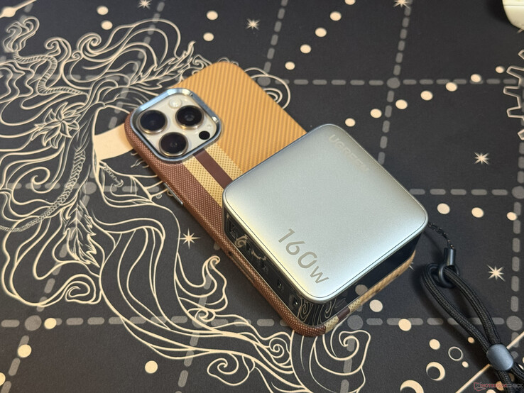 Ugreen Nexode Pro 160W med fem portar ovanpå en iPhone 16 Pro Max