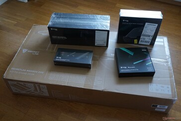 Förpackningens innehåll: Bord (stor förpackning) och tillbehör (skärmarmar, bärbar datorhållare, RGB-LED, kabelhantering)