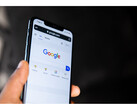 Ett fotografi av en hand som håller i en smartphone med startsidan för Google Sök öppen på skärmen. (Bildkälla: Solen Feyissa på Flickr)