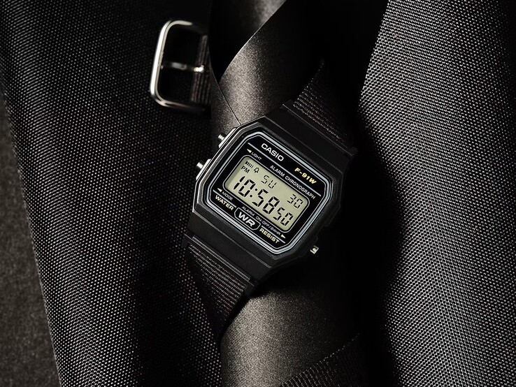 Casio F-91WF-1A digitalklocka med svart boett, svart vävd tygrem och silverfärgade detaljer, fotograferad mot en mörk, strukturerad bakgrund.