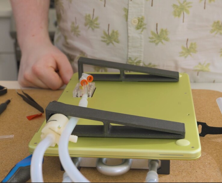 Modifierad MacBook Neo med extern pump och slangar för egentillverkad vätskekylning