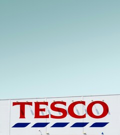Tescos utvändiga skyltar fotograferade mot en klar himmel (Bildkälla: Simone Hutsch via Unsplash)