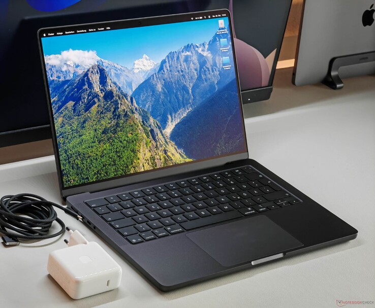 Apple MacBook Pro med M5-chip på ett skrivbord tillsammans med laddare och kabel. (Bildkälla: Notebookcheck)
