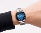 En Citizen Tsuno Chronograph med blå gradienturtavla och armband i rostfritt stål, på en handled mot vit bakgrund.