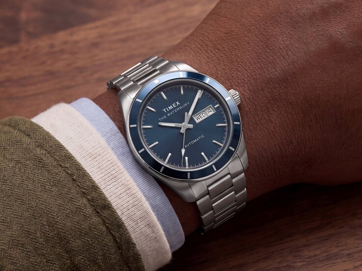 En Timex Waterbury Heritage Automatic med blå emaljurtavla bärs på handleden och visar sitt silverfärgade boett och armband i rostfritt stål.