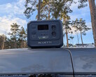 Bluetti Elite 100 V2 Bio-based på ett biltak med tallar i bakgrunden