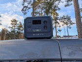 Bluetti Elite 100 V2 Bio-based på ett biltak med tallar i bakgrunden