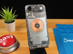 Transparent iPhone Air som visar interna komponenter och laddningsspole i koppar på ett träbord. (Bildkälla: Phone Repair Guru via YouTube)