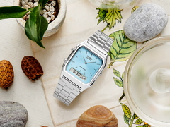 Casio AQ230A-2A1M stiliserades på ett estetiskt sätt på en bordsskiva.