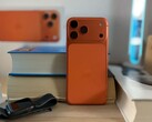 Apple iPhone 17 Air i orange utförande med bakre design och kameramodul placerad på staplade böcker