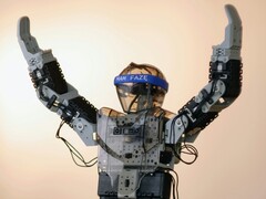 En humanoid robot med armarna i luften (Bildkälla: Adam Lukomski via Unsplash; beskuren)