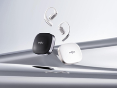 Shokz OpenFit Pro (med fodral), avbildad mot en stiliserad silverfärgad bakgrund. (Bildkälla: Shokz)