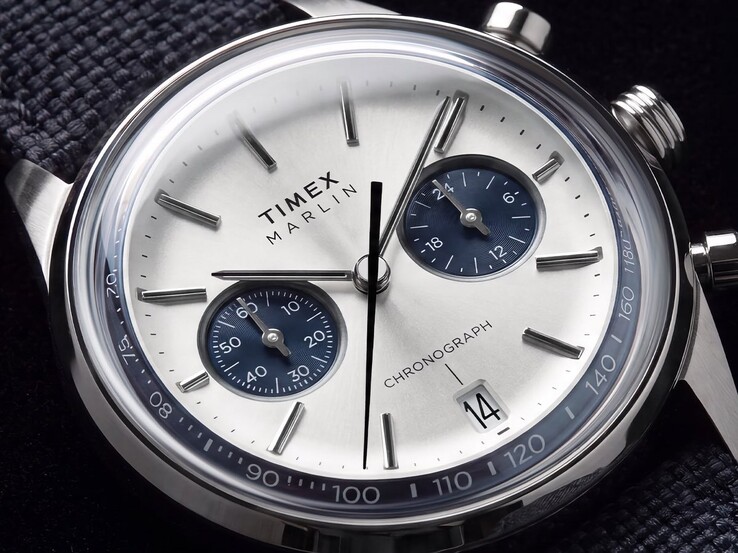 Närbild av Timex Marlin Jet Chronograph TW2Y89900 som visar dess silvervita urtavla, marinblå hjälputtavlor, påsatta timmarkörer, stavvisare, takymeterskala och datumfönster.