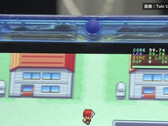 Närbild av den transparent blå FPGBA SP-handhållna konsolen som kör Pokémon, med en synlig räknare på 59.74 FPS.