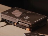 En specialbyggd kompakt spelkonsol med en mini-PC, synliga kylöppningar, USB-portar och orange strömknappar på ett skrivbord.