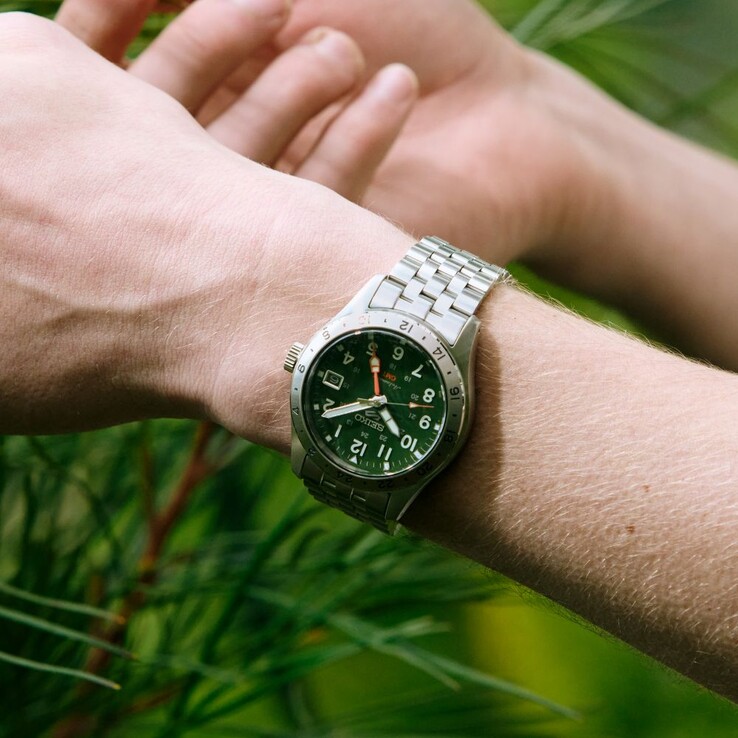 Framsidan av Seiko 5 Sports Field GMT HDB001 med grön urtavla, fast 24-timmarsring i rostfritt stål, orange GMT-visare och femlänksarmband i stål.