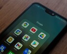 Smartphone på ett träbord med en öppen Google-appmapp