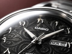 Närbild av Casio MTP-E735AR:s svarta urtavla med ett intrikat arabeskmönster, upphöjda östarabiska siffror, polerade silverfärgade visare och en dag- och datumvisning vid klockan 3.