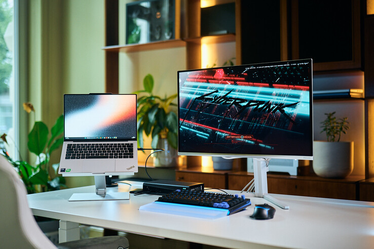Komplett arbetsstation med en ThinkPad X9 14-bärbar dator på ett stativ, en Aorus RTX 5060 Ti AI Box eGPU och en extern bildskärm som visar Cyberpunk 2077.