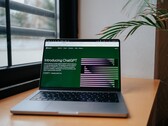 En bärbar dator på ett skrivbord vid ett fönster med OpenAI ChatGPT:s webbplats öppen på skärmen
