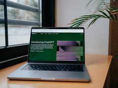 En bärbar dator på ett skrivbord vid ett fönster med OpenAI ChatGPT:s webbplats öppen på skärmen