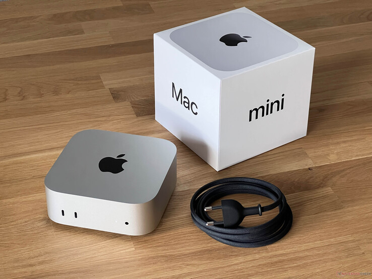 Apple Mac mini placerad bredvid sin detaljhandelsförpackning och strömkabel på en skrivbordsyta av trä (Bildkälla: Notebookcheck)