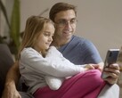 En pappa och hans dotter som tittar på en smartphone tillsammans