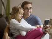 En pappa och hans dotter som tittar på en smartphone tillsammans