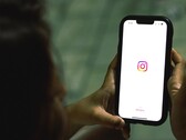 Kvinna som håller en smartphone i båda händerna, skärmen visar Instagrams startskärm