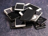 En hög med uttjänta smartphones på en grå yta