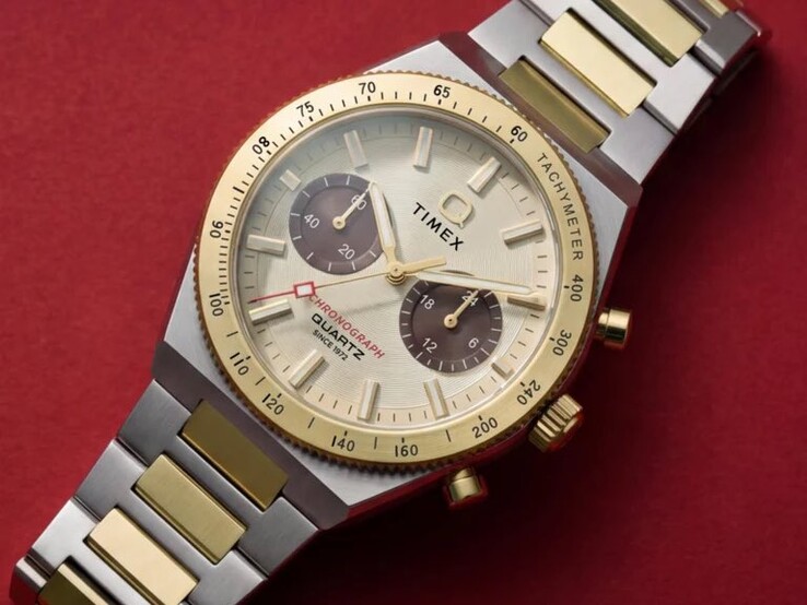Närbild på Timex Q Timex Continental Chronograph TW2Y92300 på en handled, som visar dess guldfärgade urtavla, bruna hjälpurtavlor, takymeterring och tvåfärgat armband i rostfritt stål.