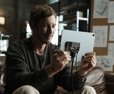 Användare som ansluter Sharge Disk Pro transparent bärbar SSD med aktiv kylning till en surfplatta via USB-C-kabel. (Sharge via Kickstarter)