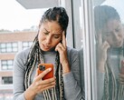 En kvinna tittar på sin smartphone med ett allvarligt uttryck