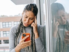 En kvinna tittar på sin smartphone med ett allvarligt uttryck
