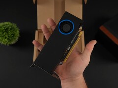 En person håller i Intel Arc Pro B50 lågprofils GPU för arbetsstationer med en fläktliknande kylare, mot dess förpackningslåda. (Bildkälla: ETA Prime via YouTube)