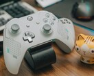Vit Xbox-kontroll vilar på ett träbord bredvid en liten kattfigur (Bildkälla: FOX ^.ᆽ.^= ∫ via Pexels)