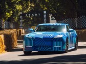 Jaguar Type 01 EV i kamouflagefärgen ”Blue Exuberant Modernism” susar förbi startlinjen i Goodwood Hill Climb